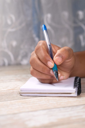 Close up of man hand writing on notepad.