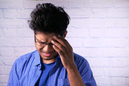 Depressed man feeling sick and worried about financial problemの写真素材