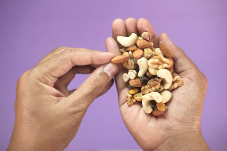 close up of man hands eating mixed nut