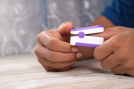 young man hand using pulse oximeter