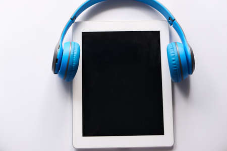 Audio book concept. Headphones and digital tablet on tableの写真素材