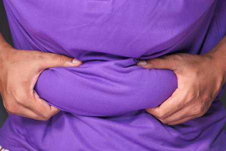 mans hand holding excessive belly fat, overweight concept