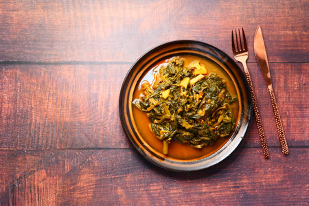 Top view of bowl with cooked spinach on table