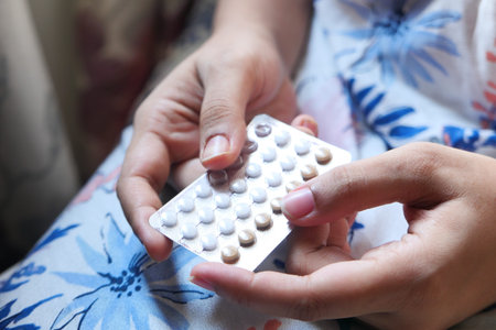 women hand golding birth control pills close up