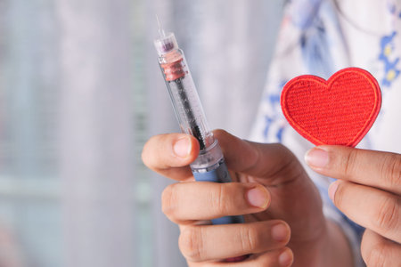 women hand holding Insulin pens and heart symbol with copy space