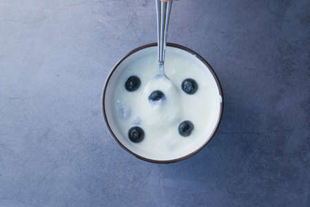 close up of fresh yogurt with blue berry in a bowlの写真素材