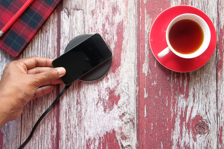 charging Smartphone Using Wireless Charging Pad, top viewの写真素材