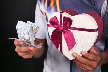 young man hand holding gift box and cash.