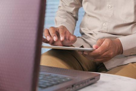 mans hand working on digital tablet on office desk