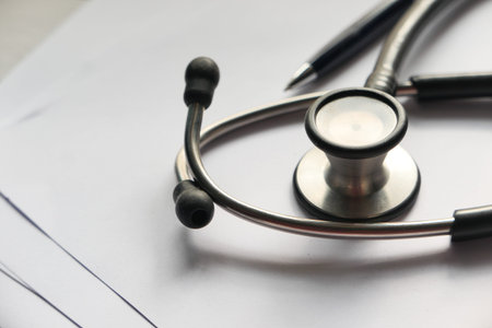 close up of stethoscope, paper and pen on clinic desk