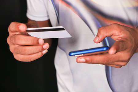 Man hand holding credit card and using smart phone shopping onlineの写真素材