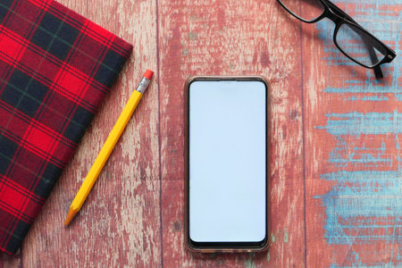 top view of smart phone and notepad on table