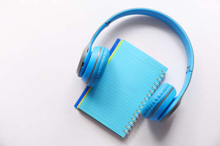 Audio book concept. Headphones and notepad on white backgroundの写真素材