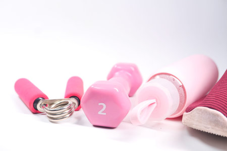 pink color dumbbell, shoe and water bottle on white background