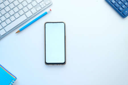 top view of smart phone and office stationary on whiteの写真素材