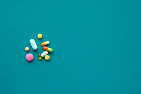 close up of colorful pills spilling on green backgroundの写真素材