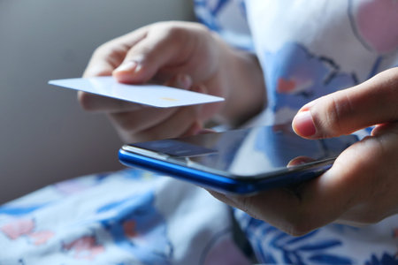 women hand holding credit card and using smart phone shopping online