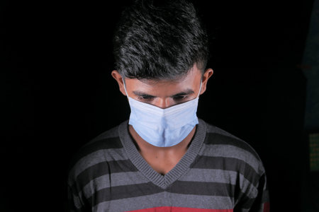 A young man with protective mask isolated on black