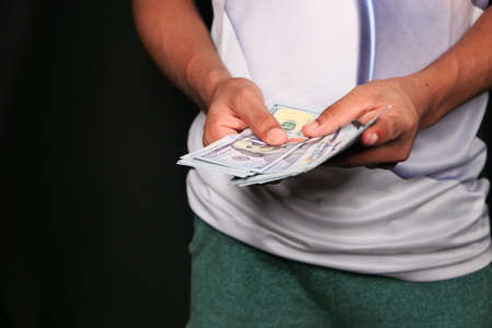 Close up of man hand counting 100 us dollar cashの写真素材