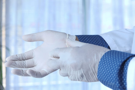 man doctor wears medical gloves, close up
