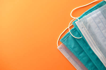 Close up of blue surgical masks on orange backgroundの写真素材