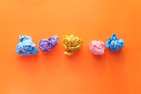 top view of crumpled paper balls on orange backgroundの写真素材