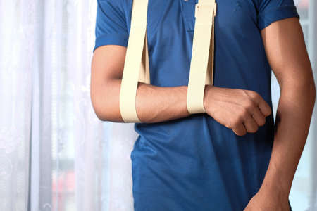 young man wearing an arm brace for broken hand .の写真素材