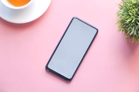 top view of smart phone with white screen on pink backgroundの写真素材