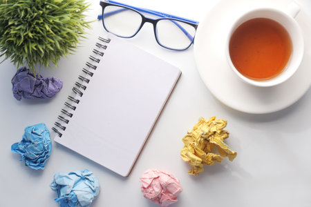 crumpled paper ball and notepad on wooden table.