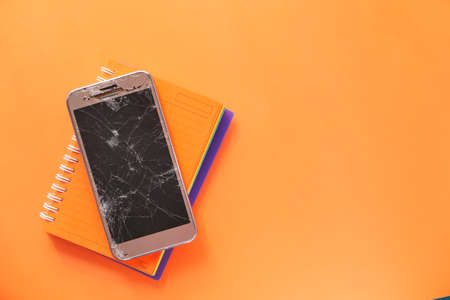 Top view of broken smart phone on color backgroundの写真素材