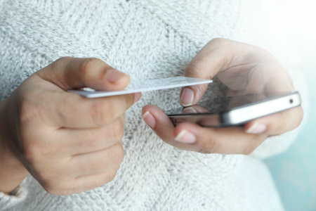 women hand holding credit card and using smart phone shopping online