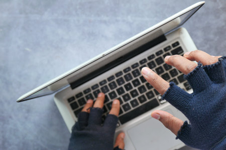 hacker hand stealing data from laptop top down