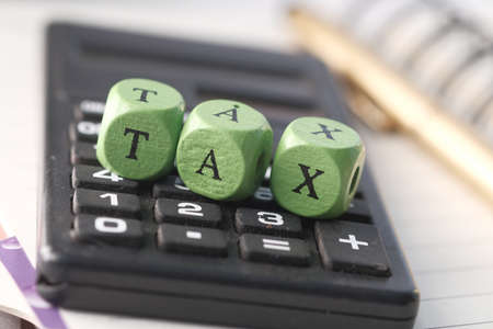Wooden block with a TAX word on calculatorの写真素材