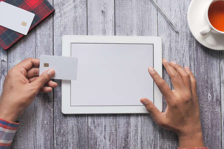 Man hand holding credit card and using digital tablet shopping onlineの写真素材