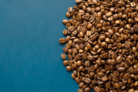 top view of fresh coffee beans on color background with copy space.