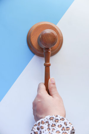 Top view of persons hand striking the gavel.の写真素材
