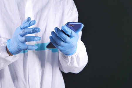 doctors hand in protective gloves using a smartphone.
