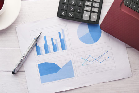 financial graph, calculator and notepad on table