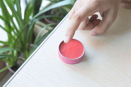woman using petroleum jelly onto skin at home close up.の写真素材