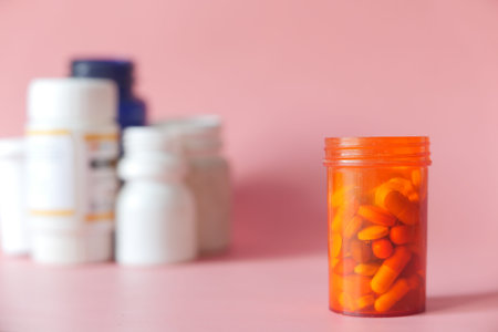 close up of pills and capsule container on pink backgroundの写真素材