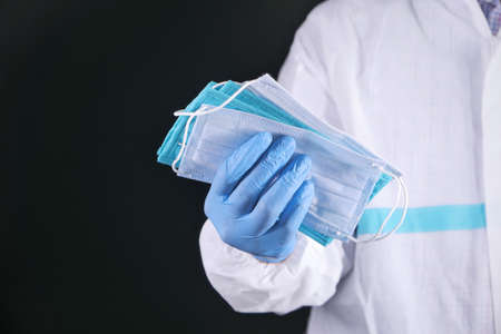 doctor hand in medical glove holding protective surgical face mask, close upの写真素材