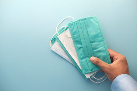 man hand holding surgical face mask, close upの写真素材