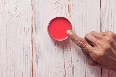 senior woman using petroleum jelly onto skinの写真素材