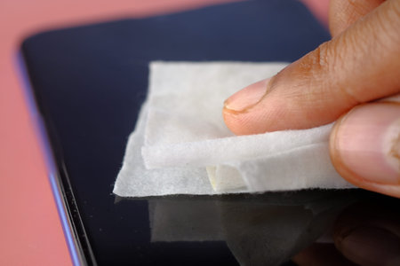 man hand cleaning mobile phone display for preventing virus