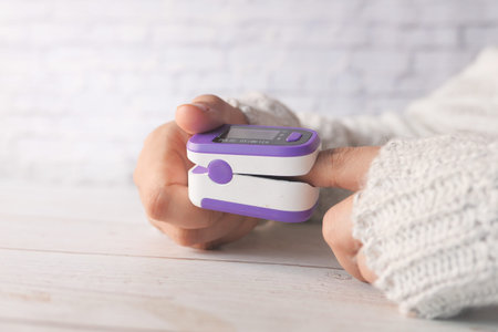 young women hand using pulse oximeter