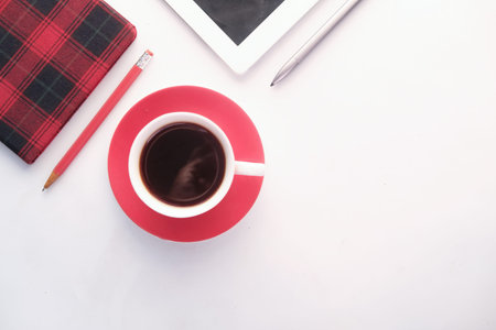 office desk with tea, notepad and digital tabletの写真素材
