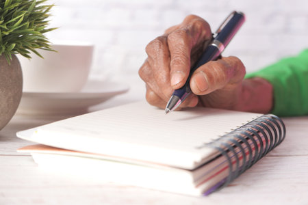 Close up of senior women hand writing on notepad.の写真素材