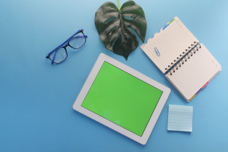 top view of digital tablet with office suppliers on blue backgroundの写真素材