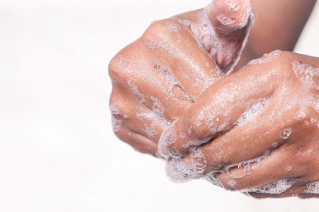 young man washing hands with soap warm water