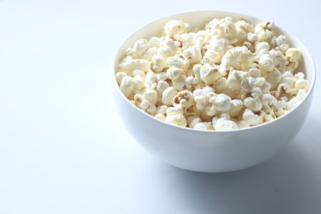 popcorn in a bowl on white backgroundの写真素材